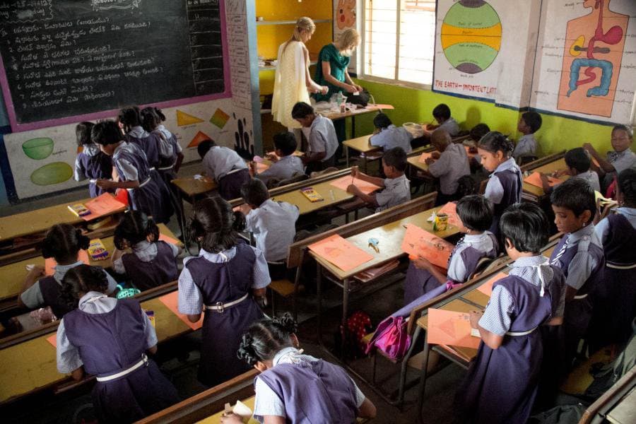 Volunteers teaching a class of students in a partner school